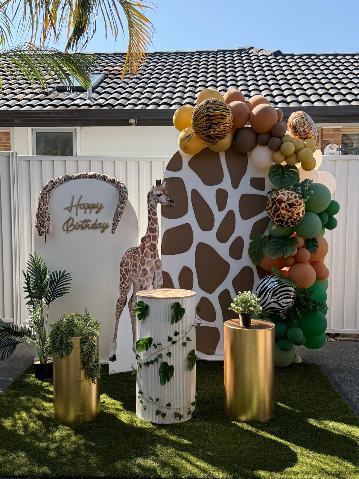 Safari jungle birthday party with giraffe cutout, animal print balloons and organic arch